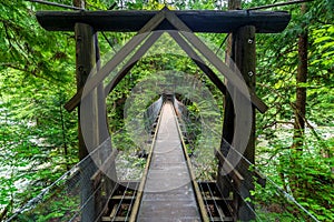 Wooden suspension bridge in the forest. Hiking in the summer forest in Japan