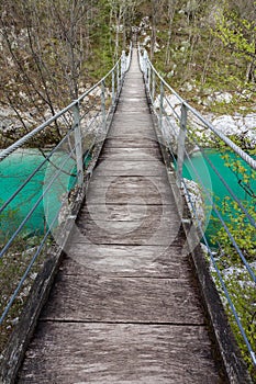 Wooden suspension bridge over the turquoise green Soca river in the Julian Alps, Slovenia, Europe