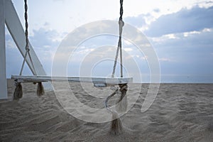 Wooden swing on beach. Coast of Indian Ocean. Deserted beach. Concept of summer holidays. Copy space.