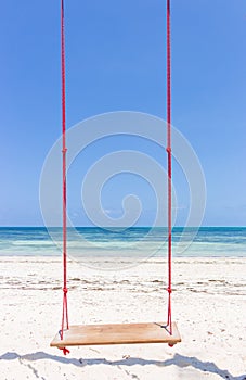 Wooden swing on the beach. Swing on scenic seascape. Idyllic exotic resort. Tropical paradise. Empty swing. Romantic vacations.