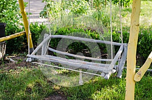 Wooden swing hand-made in the garden.