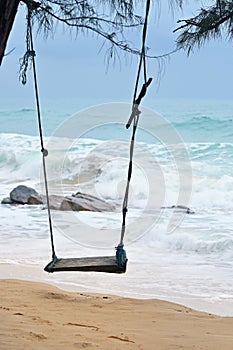 A wooden swing on the tropical island beach under beautiful blue sea and sky, Phuket, Thailand