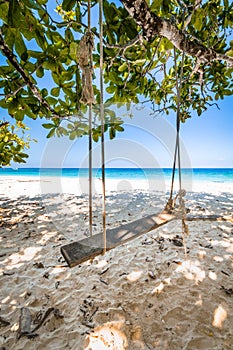 Wooden Swing and weathered rope on Beautiful tropical beach