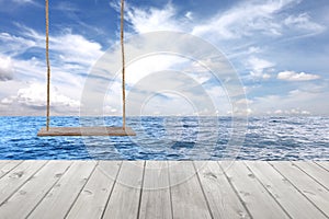 wooden swing and wood floor on sea wave in blue sky background.