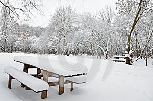 A wooden table in abandoned park on a winter evening