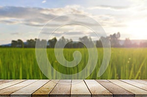 Wooden table against rice field blurry background.