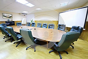 Wooden table, armchairs and background for projection