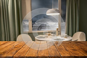 Wooden table background with free space and window and cozy home interior backgound. Winter outside the window.