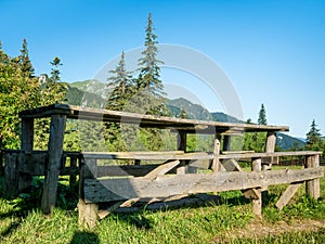 Wooden table and bench at Diham chalet with Bucegi Mountains in the background
