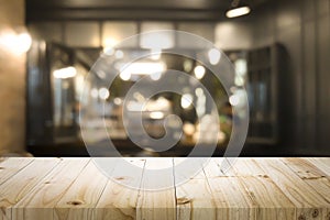 Wooden table with blur background of coffee shop.