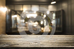 Wooden table with blur background of coffee shop.