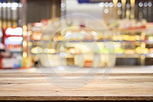 Wooden table with blur background of coffee shop.