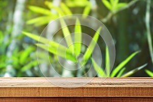 Wooden table and blur bamboo forest background.