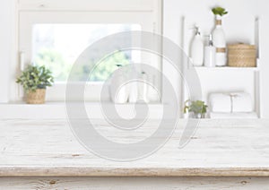 Wooden table on blurred background of bathroom window and shelves