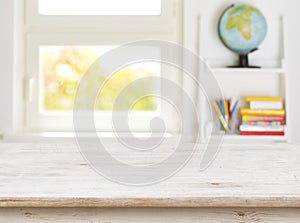 Wooden table with blurred background of kids room and window