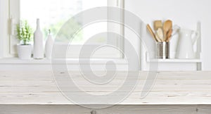 Wooden table on blurred background of kitchen window and shelves