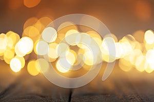 Wooden table and blurred bokeh background with warm orange lights. Christmas light bokeh