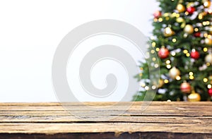 Wooden table and blurred Christmas tree with fairy lights