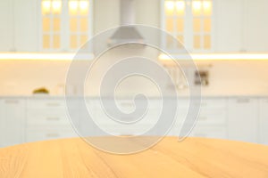 Wooden table and blurred view of kitchen interior on background