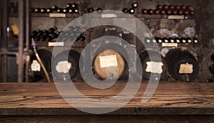 Wooden table on blurry background of wine barrels and bottles