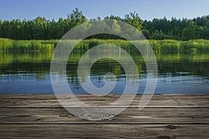 Wooden table from boards on landscape of lake