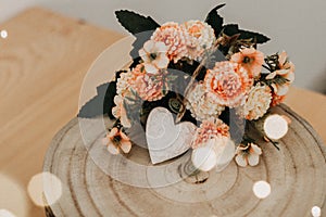 Wooden table with a bouquet of flowers and a white heart