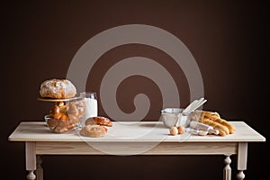 Wooden table on a brown background with baked goods, bread, buns photo