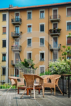 Wooden table and chairs on an outdoor terrace in a residential neighbourhood during the summer.