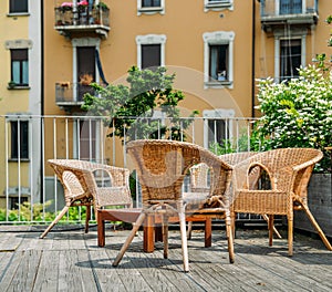 Wooden table and chairs on an outdoor terrace in a residential neighbourhood during the summer.