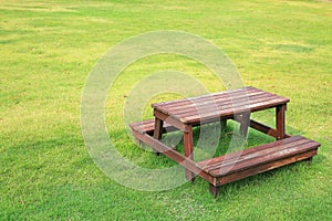 Wooden table and chairs set on green lawn in the garden