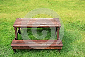 Wooden table and chairs set on green lawn in the garden