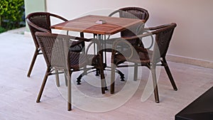 Wooden table with chairs standing on summer terrace