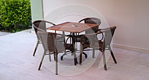 Wooden table with chairs standing on summer terrace