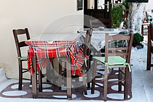 Wooden table with chairs at traditional Greek cafe