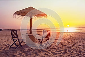 Wooden table and chairs with umbrella on the beach