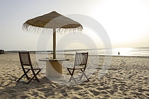 Wooden table and chairs with umbrella on the beach