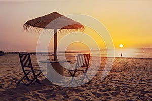 Wooden table and chairs with umbrella on the beach