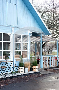 Wooden table and chairs on veranda of house. Exterior street cafe with furnuture. Outdoor home decor.