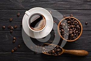 Wooden table with coffee beans in scoop composition. Vintage wood background texture and old spoons with grains top view