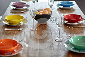 Wooden table with colourful dinnerware.