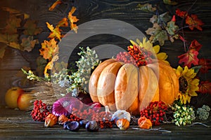 The wooden table decorated with vegetables, pumpkins and autumn leaves. Autumn background. Schastlivy von Thanksgiving