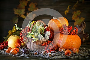 The wooden table decorated wild with flowers by pumpkins and autumn leaves. Autumn background. Happy Thanksgiving Day