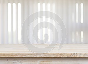 Wooden table on defocuced window with jalousie background
