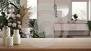 Wooden table, desk or shelf close up with ceramic vases with cotton flowers over modern bathroom with houseplants, urban jungle