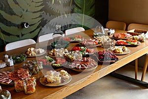 Wooden table with different types of snacks on holiday