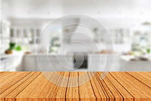 A wooden table for displaying products against a blurred white kitchen background.