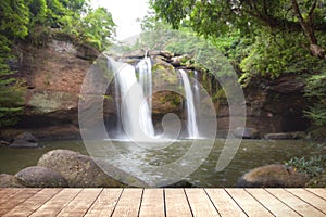 Wooden table with environmental in water fall forest.