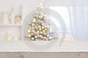 Wooden table in front of abstract blurred Christmas decorations background