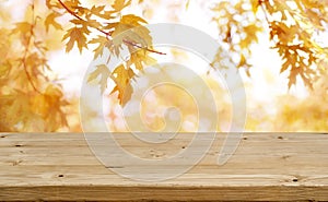 Wooden table in front of abstract blurred colorful autumn background