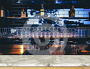 Wooden table in front of abstract blurred restaurant lights background of bar